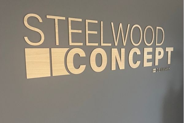 Steelwood Concept logo i træ på grå væg