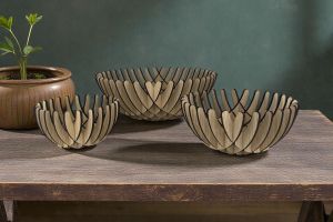 3 skåle i forskellige størrelser. Sat på et bord af træ ved en olivengrøn væg