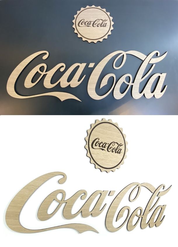 To gange Coca Cola Logo i træ. På grå og Hvid baggrund med dekorativ graveret kapsel.