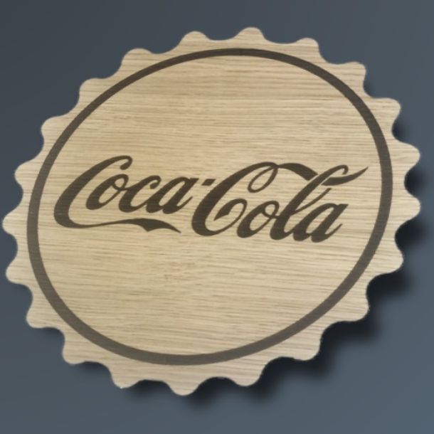 Kapsel udskåret i træ med Coca Cola logo graveret i midten.