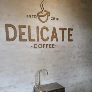 Logo i træ med laserskæring. Delicate Coffee showroom
