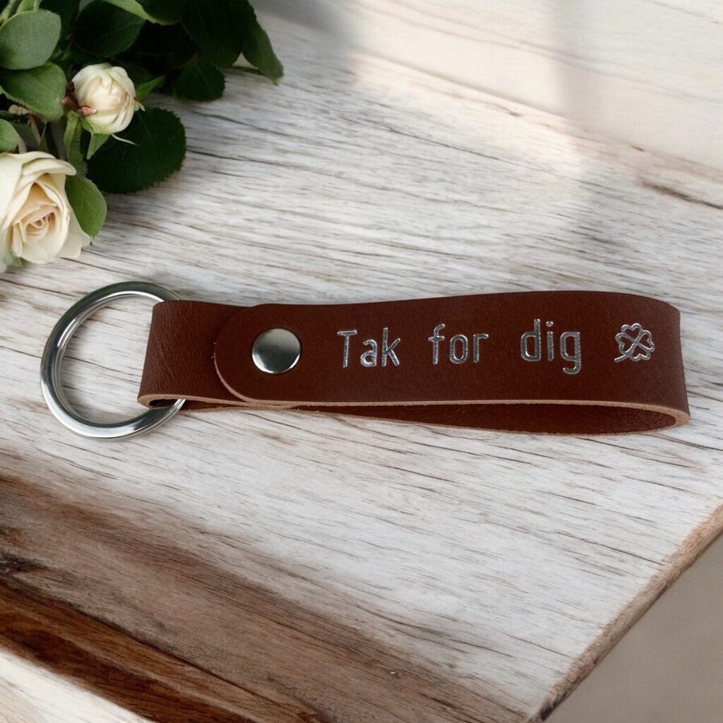 Cognac lædernøglering med sølvtryk. Tekst Tak for dig og et symbol med en firkløver.