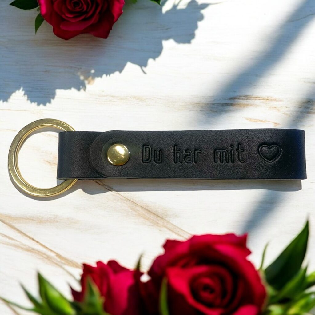 Nøglering i sort læder med tryk og sølv nøglering og nitte. Der står Du har mit hjerte