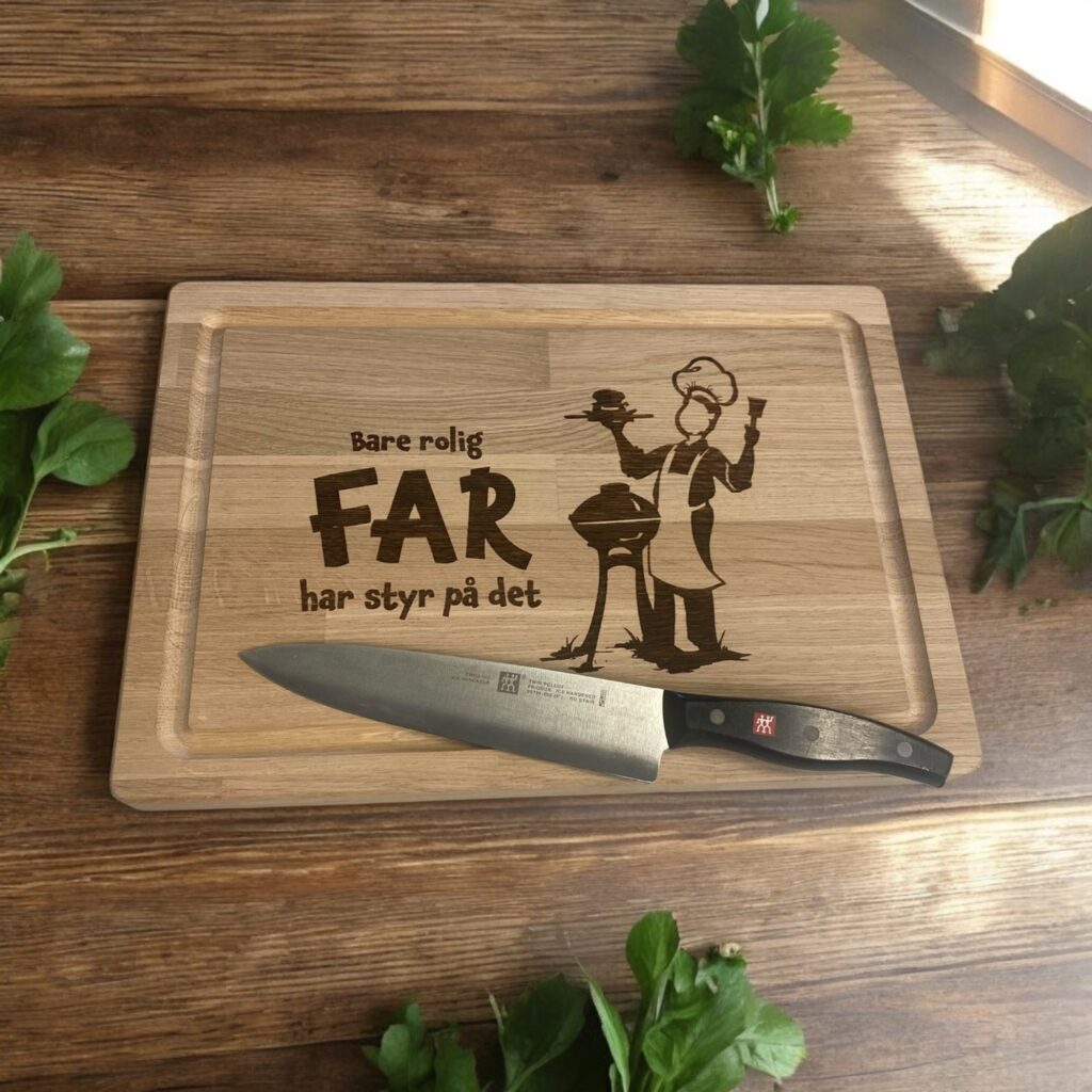 Skærebræt i massiv eg med teksten Bare rolig - Far har styr på det. Teksten er graveret sammen med far der står ved grillen.