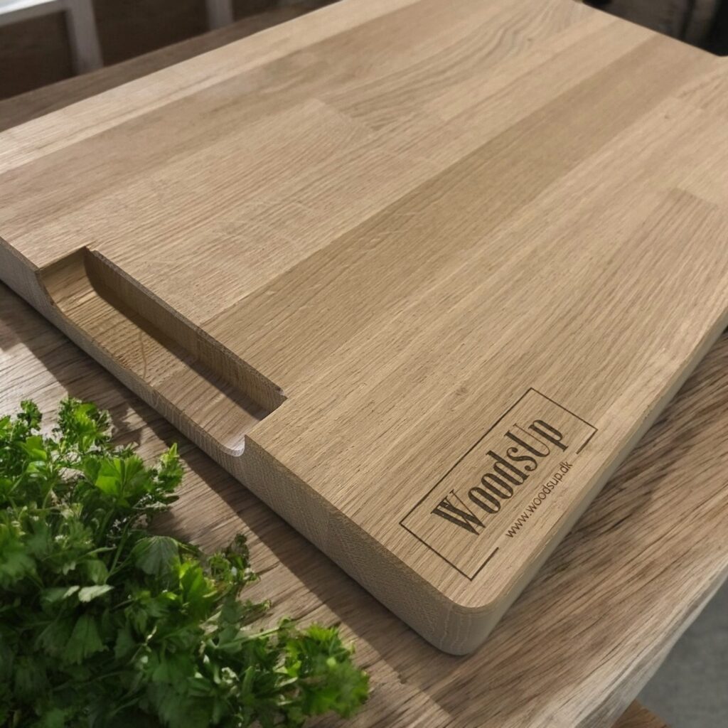 Undersiden af skærebrættet. WoodsUp logo i venstre hjørne og synlige greb.