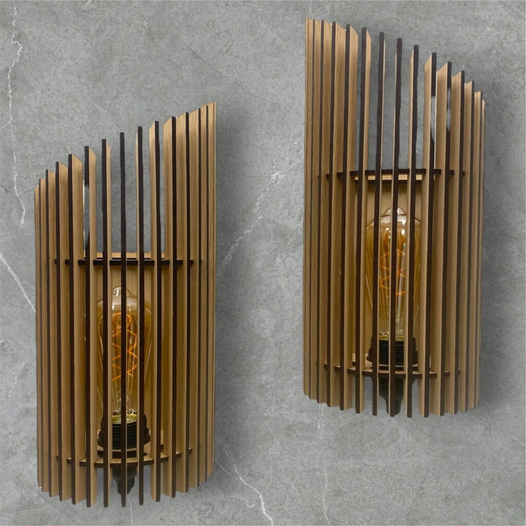 Twister væglamper i træ. Lavet af lameller i træ med forskellige højder. Lamperne hænger på en grå væg.