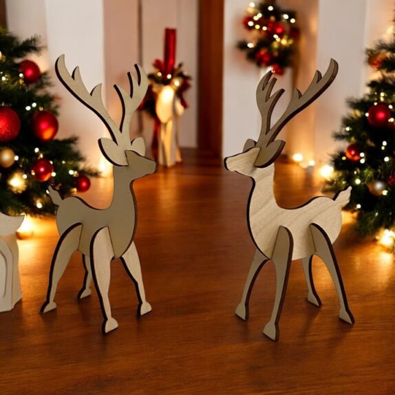 To små rensdyr i træ som står på et bord med julestemning.