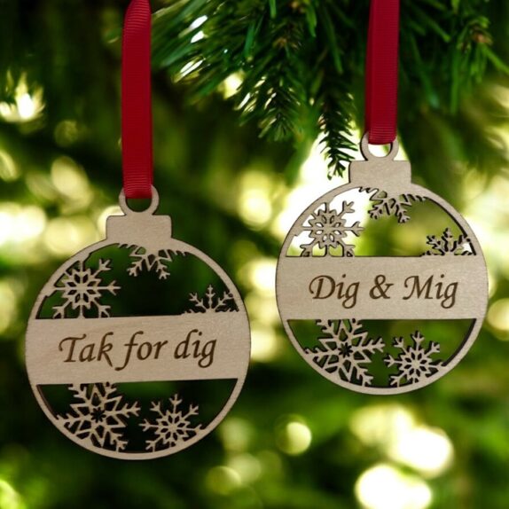 To personlige julekugler i træ med rødt bånd. På den ene står der Tak for dig og på den anden Dig & Mig.