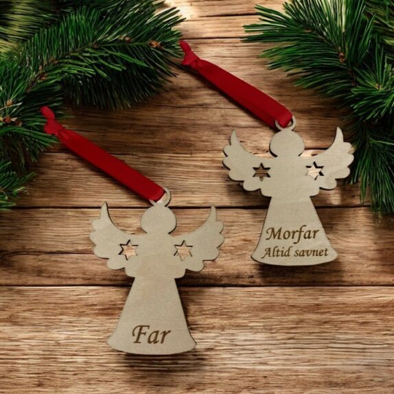 Personlige engle med navn i træ. To stk. med rødt bånd på et bord med gran.