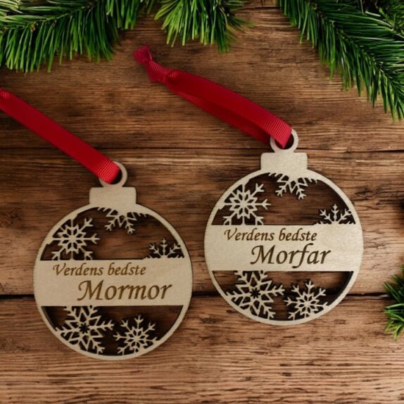 Julekugler i træ med navn og rødt silkebånd. 2 stk. med graveringer hvor der står Mormor og Morfar.